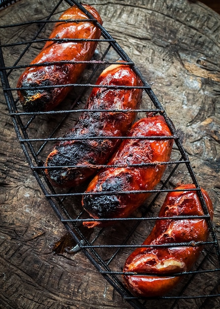 Grigliare le salsicce sulla griglia del barbecue