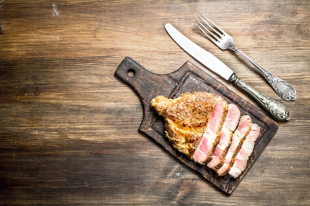 Grigliata di manzo con spezie su un tagliere. Su un tavolo di legno.