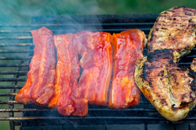 Grigliata mista assortita di carne di pollo e maiale, salsicce arrostite sulla griglia del barbecue cotte per la cena estiva in famiglia.