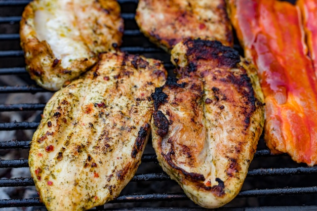 Grigliata mista assortita di carne di pollo e maiale, salsicce arrostite sulla griglia del barbecue cotte per la cena estiva in famiglia.