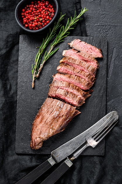 Grill Restaurant Beef - Bistecca di fianco su una tavola di pietra nera.