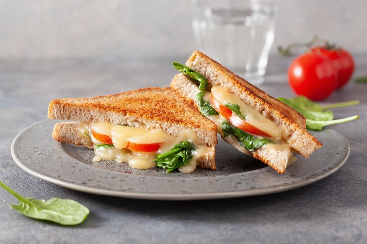 Photo grilled cheese spinach and tomato sandwich on concrete background