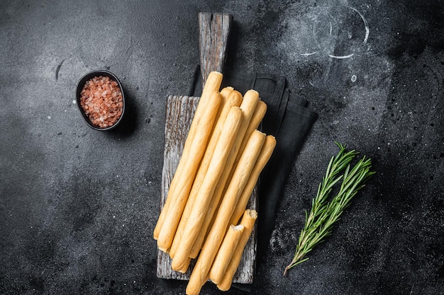 Grissini italiani o grissini salati su tavola di legno Bakground nero Vista dall'alto