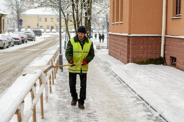 Grodno Bielorussia 11 gennaio 2019 tempesta di neve in città Strade e marciapiedi ricoperti di neve La pala del lavoratore cancella la neve Il cattivo tempo invernale Pulizia delle strade dopo la tempesta di neve