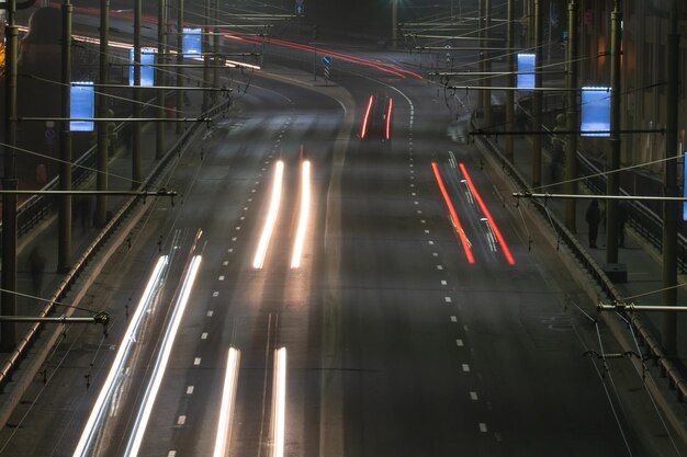 Grodno Bielorussia 17 giugno 2020 Città notturna I sentieri di luce sulla strada Foto a bassa velocità dell'otturatore Un lungo ponte sul fiume conduce alla grande città Una trafficata superstrada nel centro della città