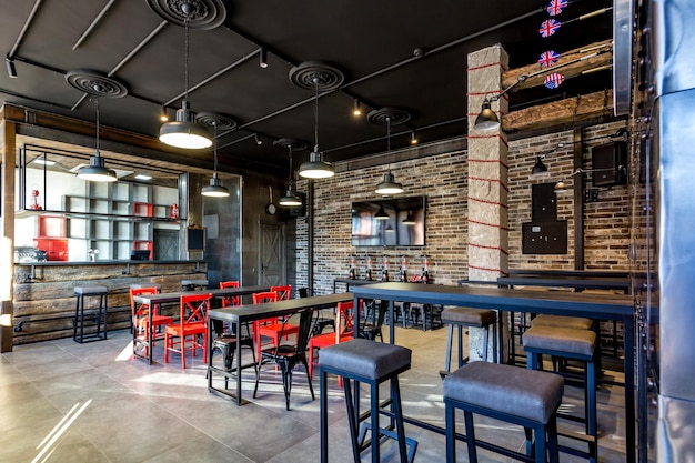 GRODNO BIELORUSSIA MARZO 2019 interni interni in moderno pub sport bar con stile loft scuro con sedie rosse