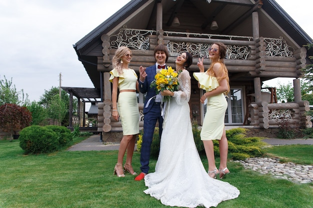 Groomsmen e damigelle con sposi novelli alla cerimonia di nozze