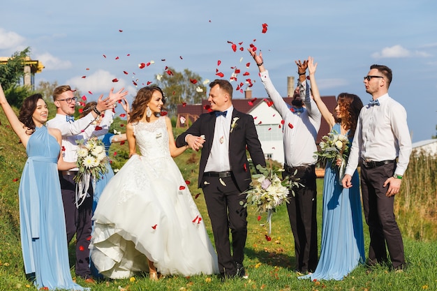 Groomsmen e damigelle con sposi novelli alla cerimonia di nozze