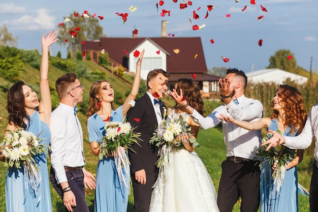 Groomsmen e damigelle d'onore con appena sposati alla cerimonia di nozze