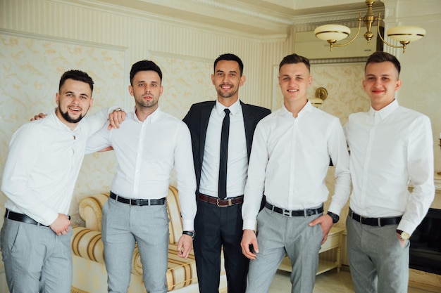 Groomsmen e sposo in posa il giorno del matrimonio.