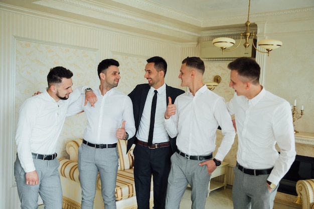 Groomsmen e sposo in posa il giorno del matrimonio.