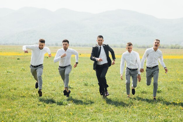 Groomsmen e sposo in posa il giorno del matrimonio.