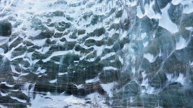 Grotte di ghiaccio blu trasparenti, bellissimo ghiacciaio di ghiaccio blu vatnajokull nei paesaggi islandesi. Rocce di ghiaccio spaccate dal gelo coperte in Islanda, scenario nordico polare con neve. Scatto a mano libera.