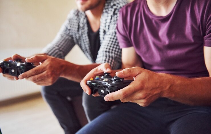 Photo group of friends have fun playing console game indoors at living room.