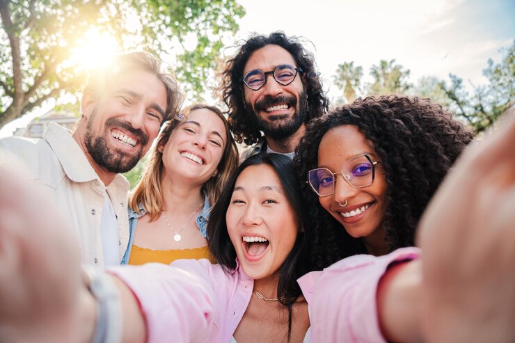 Group of multiracial young people smiling and taking a selfie together close up portrait of happy