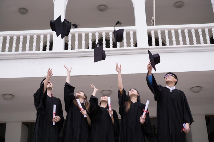 Group of Successful students with congratulations together throwing graduation hats in the air and celebrating Education concept