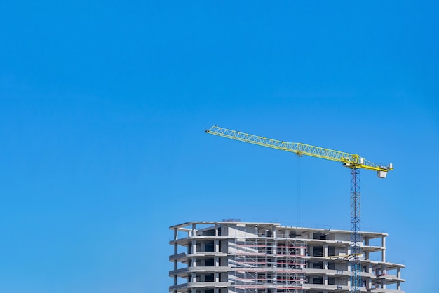 Gru a torre davanti a un edificio in costruzione sullo sfondo di un cielo limpido