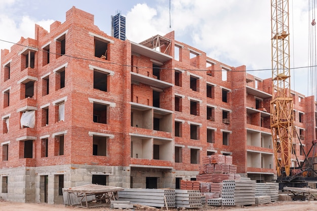 Gru a torre e lastre di cemento vicino alla casa in cantiere