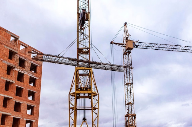 Gru a torre in cantiere vicino a casa di mattoni