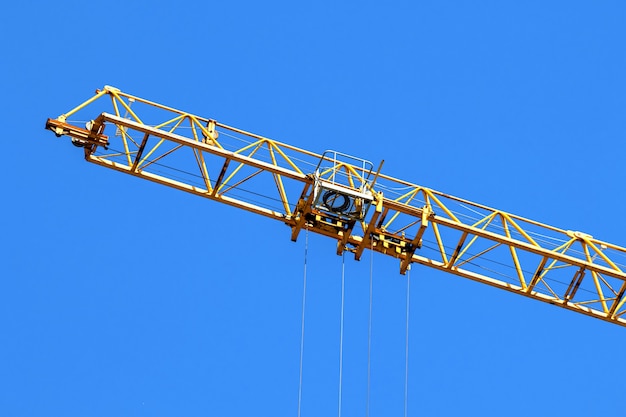 Gru da cantiere che opera e solleva il carico, foto di sfondo del cielo blu