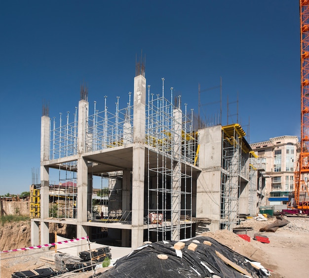 Gru da cantiere e una struttura in cemento dell'edificio su uno sfondo il cielo