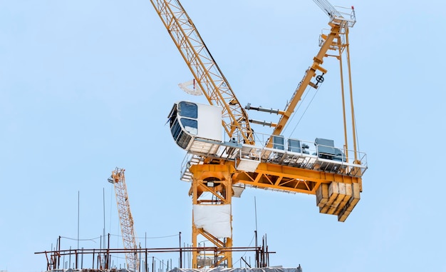 Gru da costruzione a torre in cantiere sul tetto con sfondo blu cielo