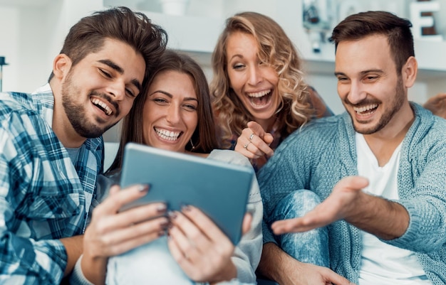 Gruppo allegro di amici che si divertono a casa, prendendo selfie.