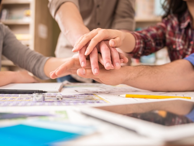 Gruppo creativo di designer che uniscono le mani.