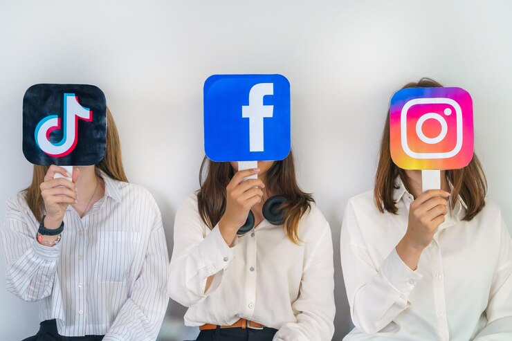 gruppo di adolescenti con i loghi di Facebook Instagram TikTok su sfondo grigio
