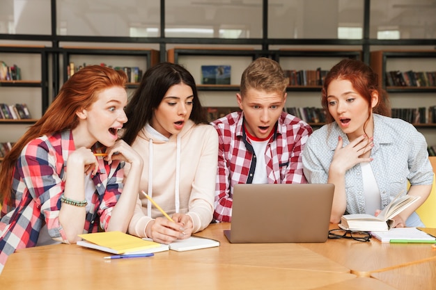 Gruppo di adolescenti entusiasti che fanno i compiti