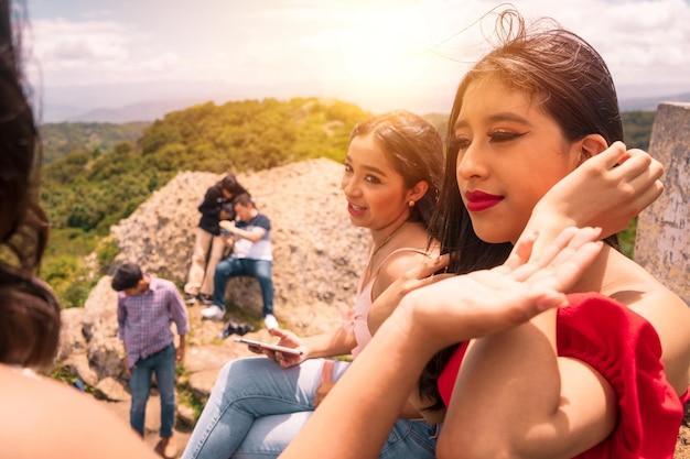 Gruppo di adolescenti latini che parlano in cima a una montagna