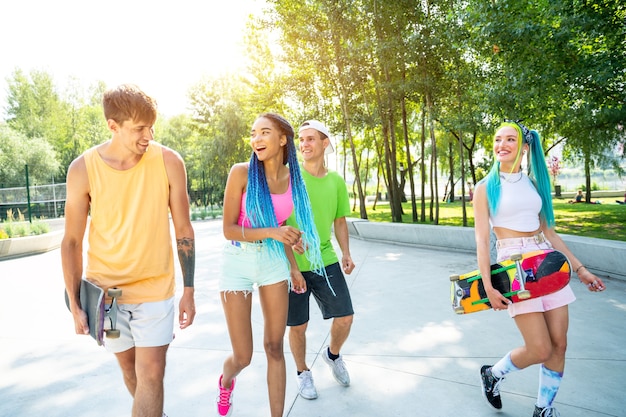 Gruppo di adolescenti pattinatori allo skatepark. Skateboarder professionisti che si divertono insieme