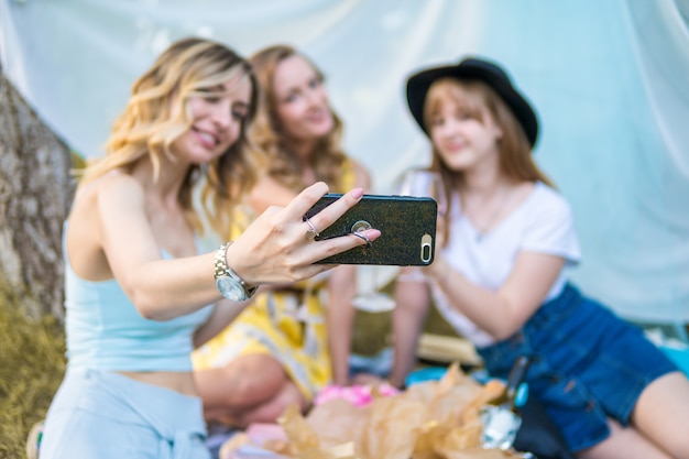 Gruppo di amiche che fanno picnic all'aperto. Fanno selfie foto da smartphone. addio al nubilato