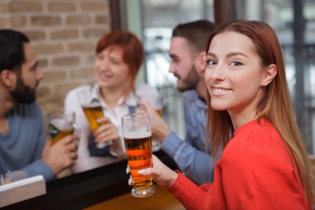 Gruppo di amici che bevono birra al pub insieme