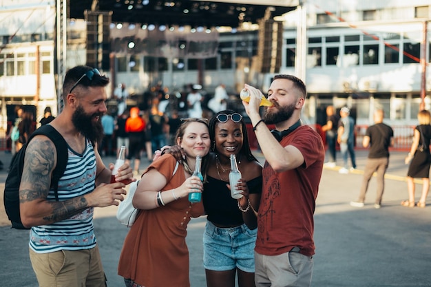 Gruppo di amici che bevono cocktail e si divertono al festival musicale