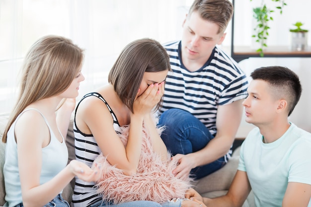 Gruppo di amici che cercano di supportare il loro amico. Giovani che calmano un amico.