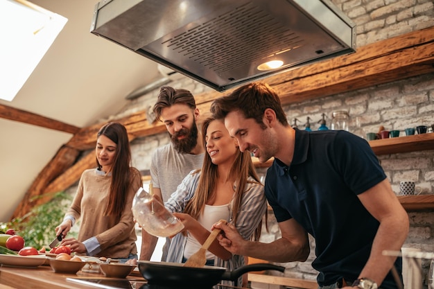 Gruppo di amici che cucinano in cucina