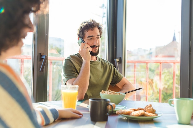 Gruppo di amici che fanno colazione insieme nella nuova casa