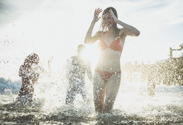 Gruppo di amici che fanno grande festa e giochi sulla spiaggia