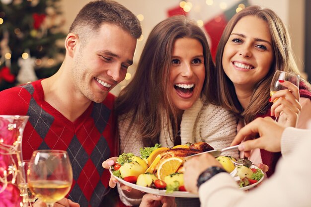 gruppo di amici che festeggiano il Natale a casa