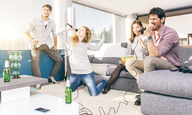 Gruppo di amici che giocano a karaoke a casa