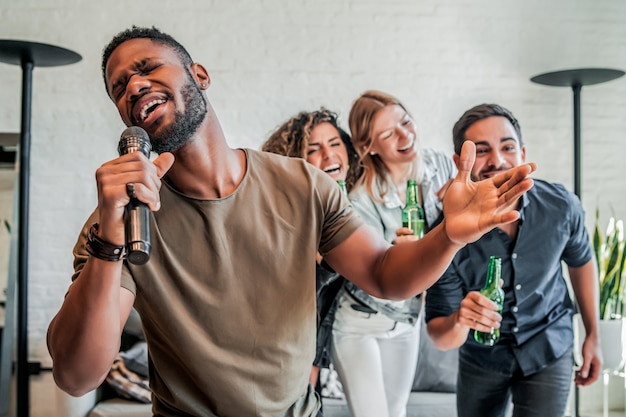 Gruppo di amici che giocano a karaoke a casa.