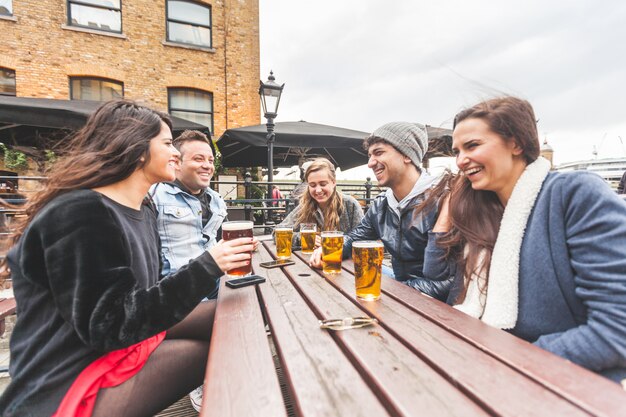 Gruppo di amici che godono di una birra al pub a Londra