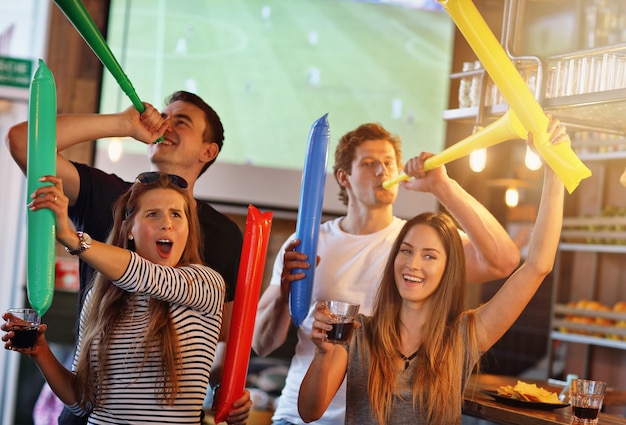 Gruppo di amici che guardano la partita di calcio al pub