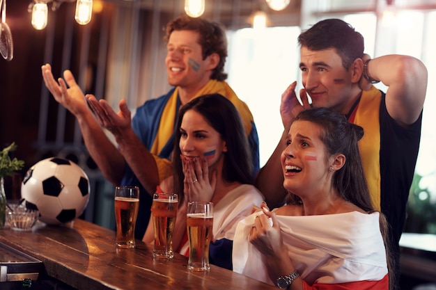 Gruppo di amici che guardano la partita di calcio al pub