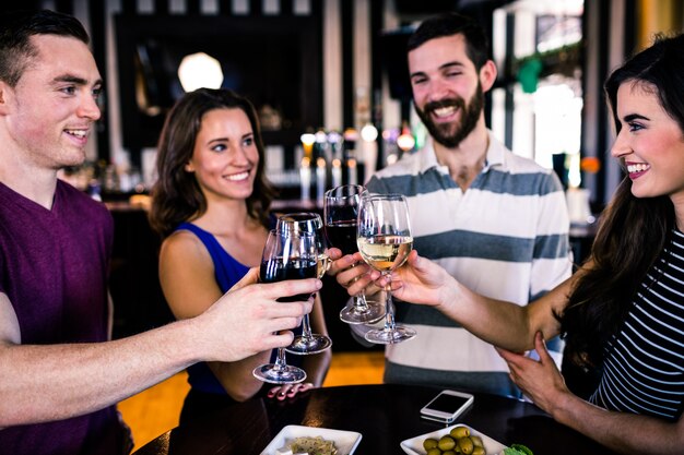 Gruppo di amici che hanno un bicchiere di vino in un bar