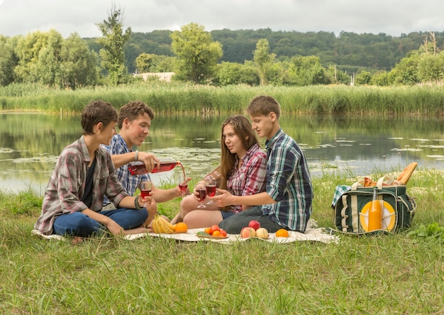 Gruppo di amici che hanno un picnic vicino al fiume