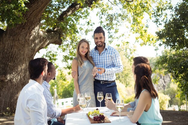 Gruppo di amici che interagiscono tra loro pur avendo champagne