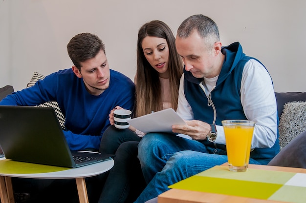 Gruppo di amici che lavorano sulla loro piccola impresa a casa. Team di uomini d&#39;affari di successo che hanno una riunione. Sorridere uomini d&#39;affari che lavorano a casa