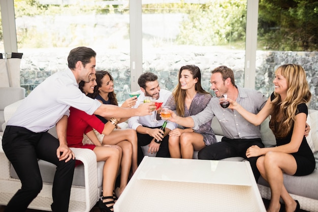 Gruppo di amici che parlano tra loro e cocktail drink alla festa